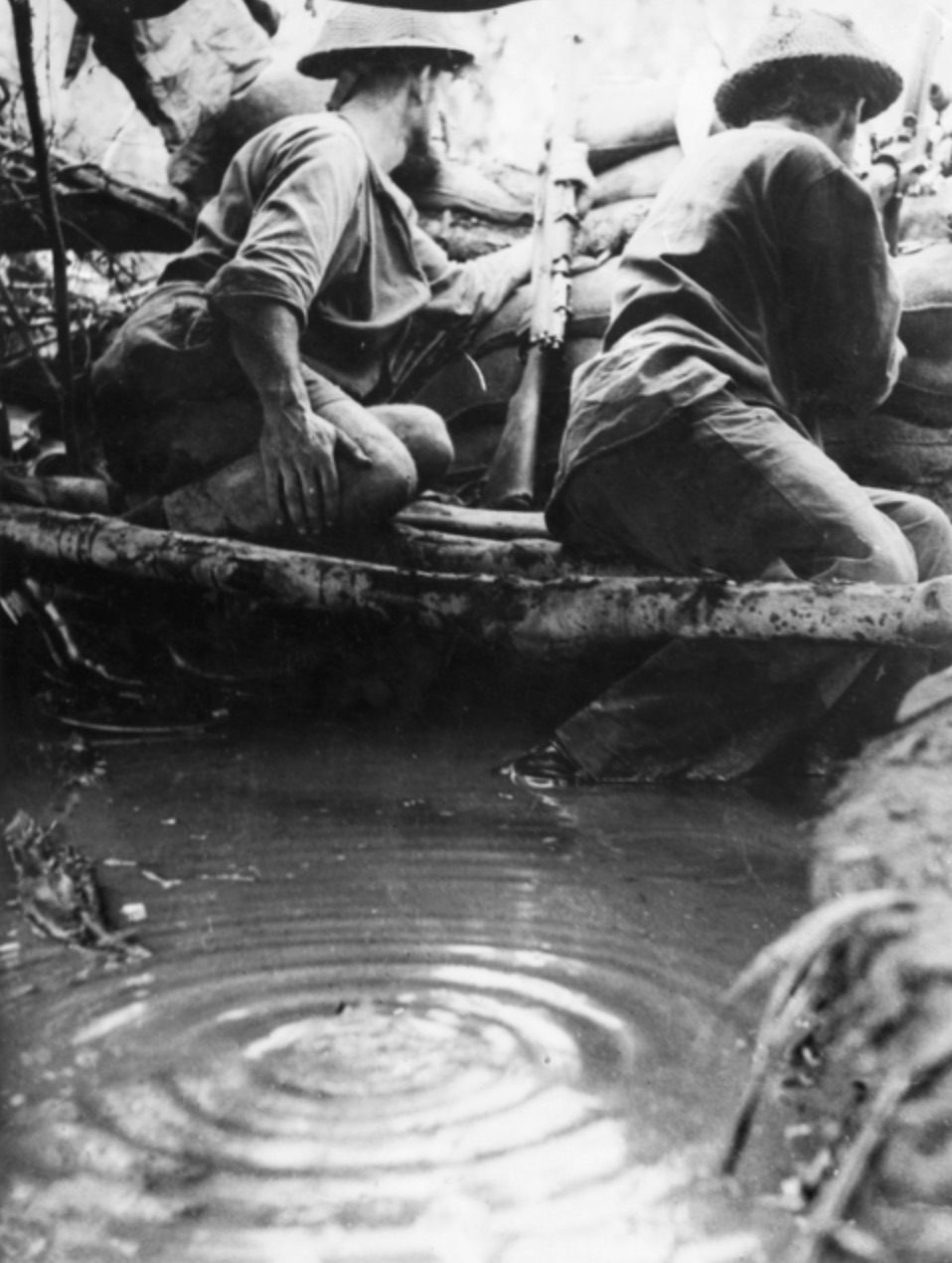 Soldiers stand-to in a weapon pit filled with rainwater. 